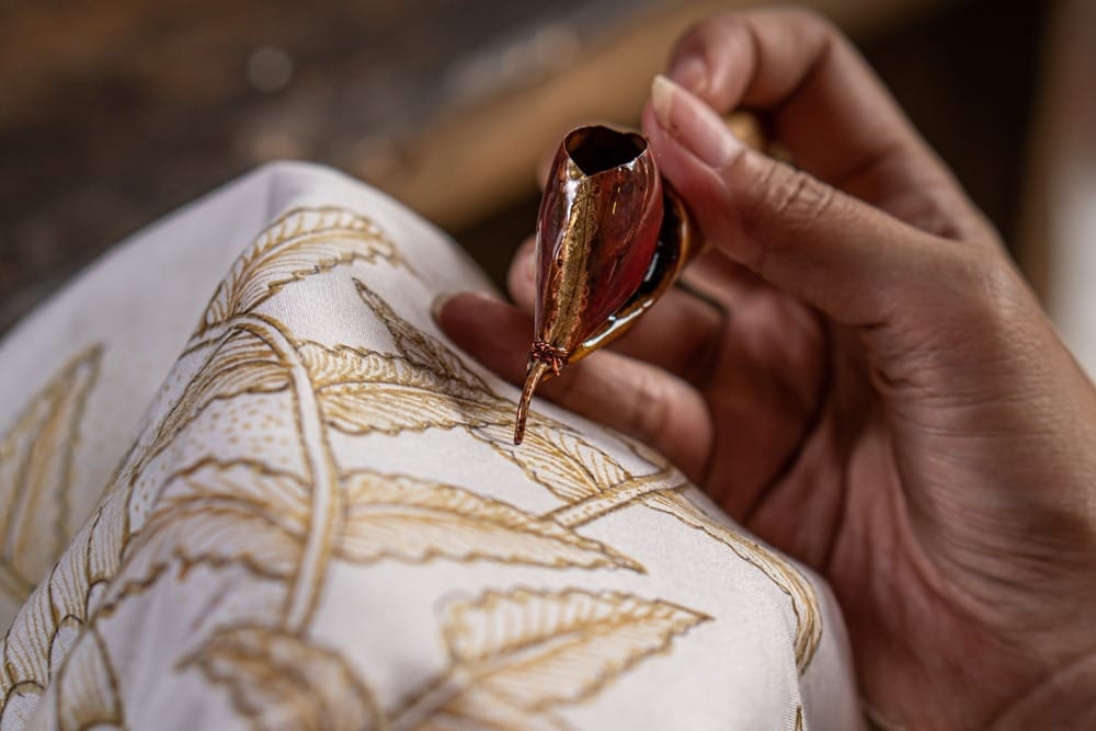 Proses pembuatan batik Indonesia dengan motif bunga.